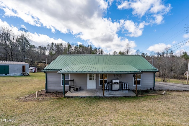 back of property with a lawn and a patio area