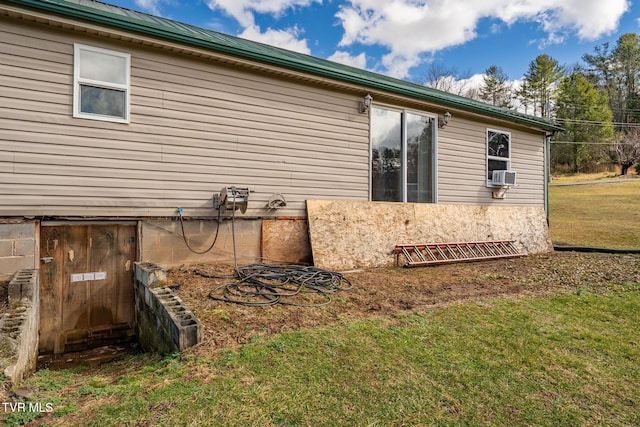 view of home's exterior with cooling unit and a yard