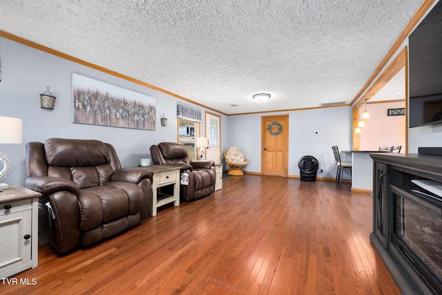 living room featuring crown molding, wood-type flooring, and a textured ceiling