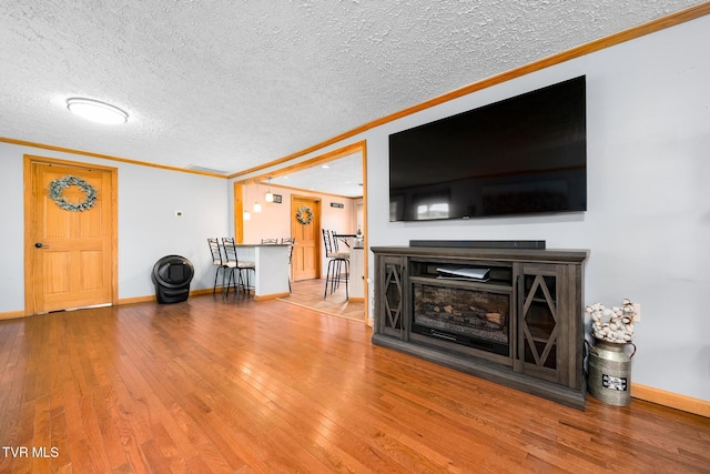 unfurnished living room with hardwood / wood-style flooring, crown molding, and a textured ceiling