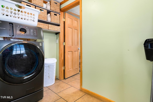 laundry area featuring washer / dryer and light tile patterned flooring