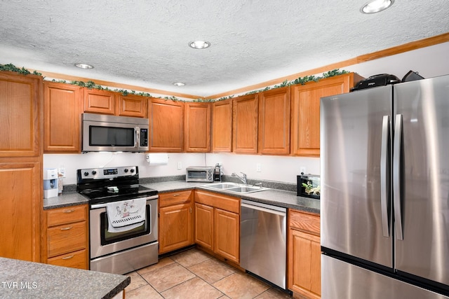 kitchen featuring appliances with stainless steel finishes, sink, and a textured ceiling