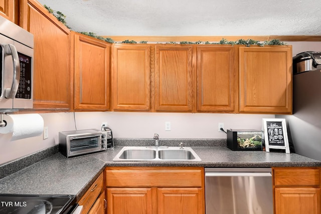 kitchen with sink, a textured ceiling, and appliances with stainless steel finishes