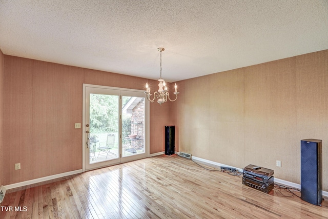205 Donegal Way Unit 205, Bristol, TN 37620 - empty room featuring hardwood / wood-style flooring, a textured ceiling, baseboards, visible vents, and a notable chandelier