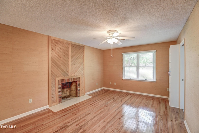 205 Donegal Way Unit 205, Bristol, TN 37620 - unfurnished living room featuring wood finished floors, a fireplace with flush hearth, a textured ceiling, baseboards, and ceiling fan