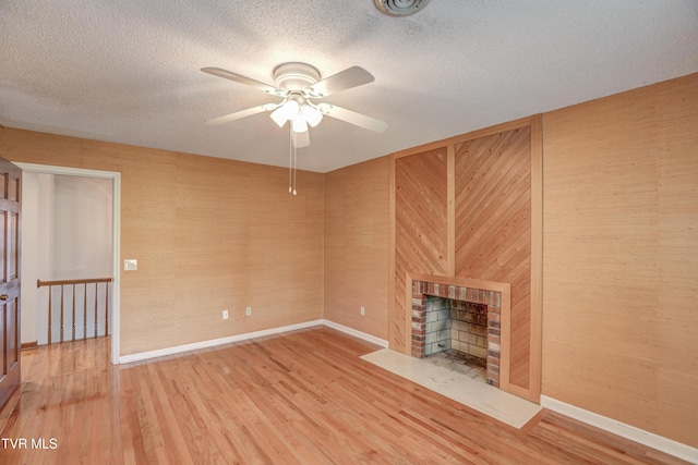 205 Donegal Way Unit 205, Bristol, TN 37620 - unfurnished living room with wood finished floors, a fireplace with flush hearth, a textured ceiling, baseboards, and ceiling fan