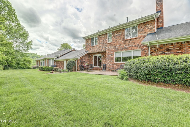 205 Donegal Way Unit 205, Bristol, TN 37620 - rear view of property featuring brick siding, a chimney, a lawn, and a patio area