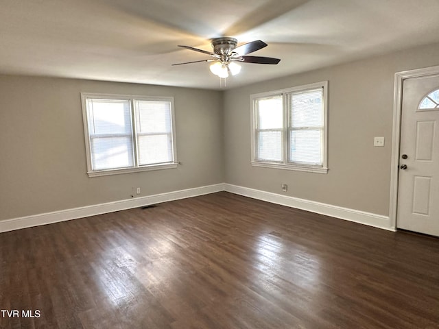 entrance foyer featuring visible vents, dark wood-style floors, baseboards, and a wealth of natural light