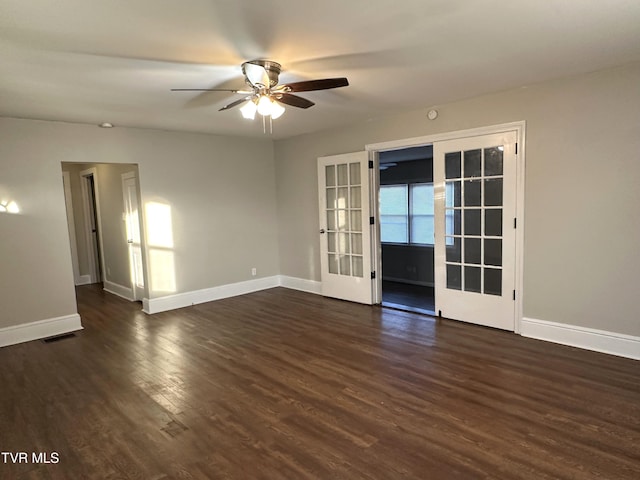 empty room with visible vents, baseboards, and dark wood-style floors