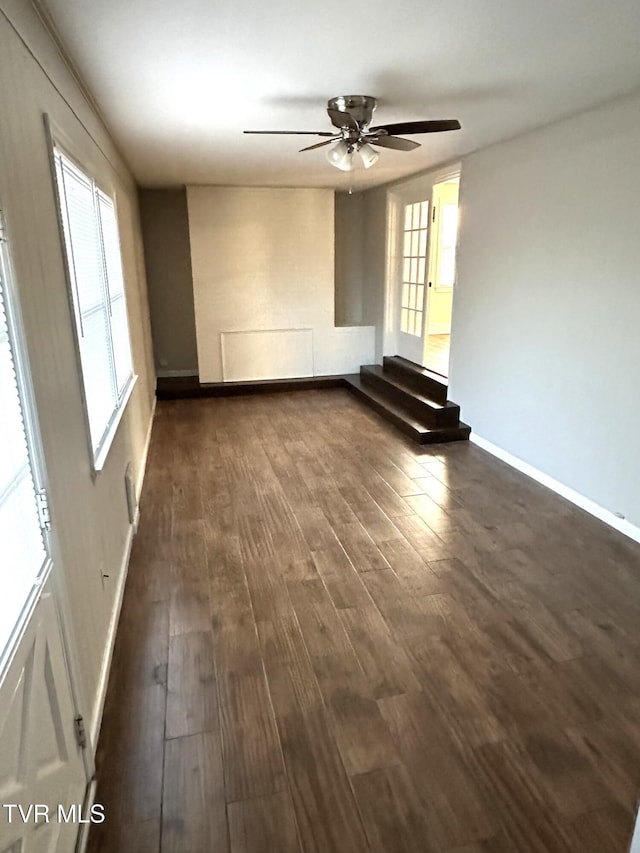 spare room with dark wood-style floors, ceiling fan, and baseboards