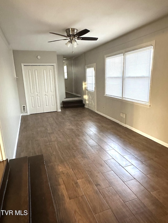 unfurnished bedroom featuring visible vents, baseboards, a closet, and dark wood-style floors