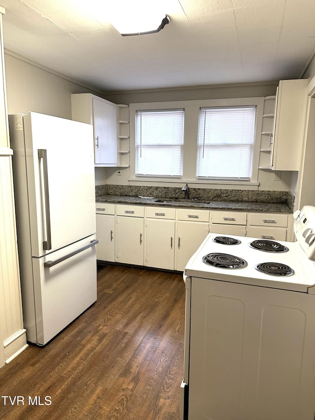 kitchen featuring white appliances, dark wood-style floors, open shelves, a sink, and dark countertops