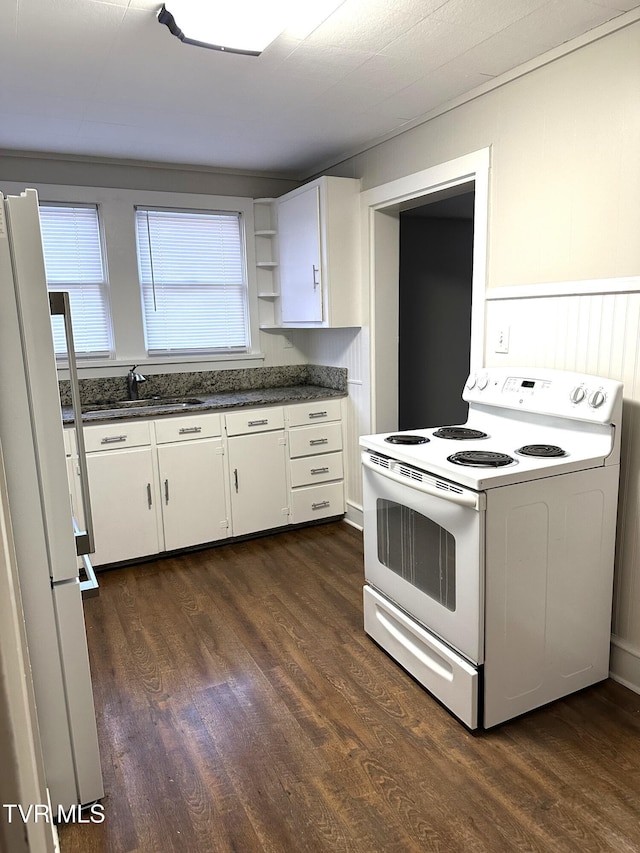 kitchen with a sink, white appliances, dark countertops, and dark wood-type flooring