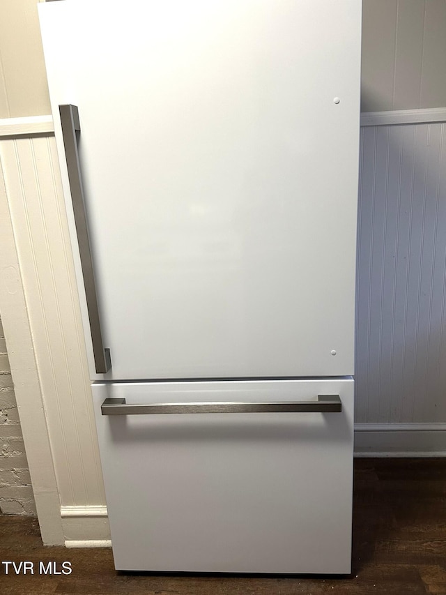 details with wood finished floors and freestanding refrigerator