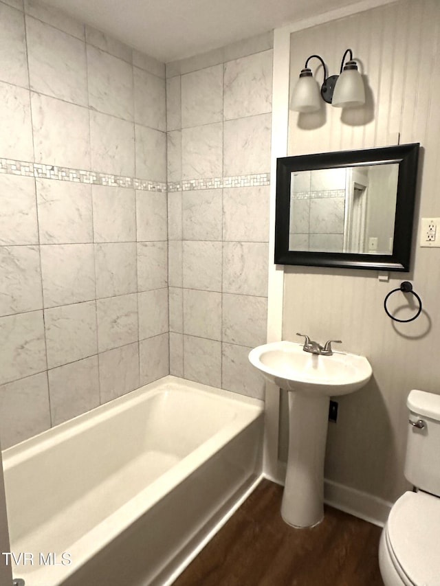 bathroom with baseboards, toilet, and wood finished floors