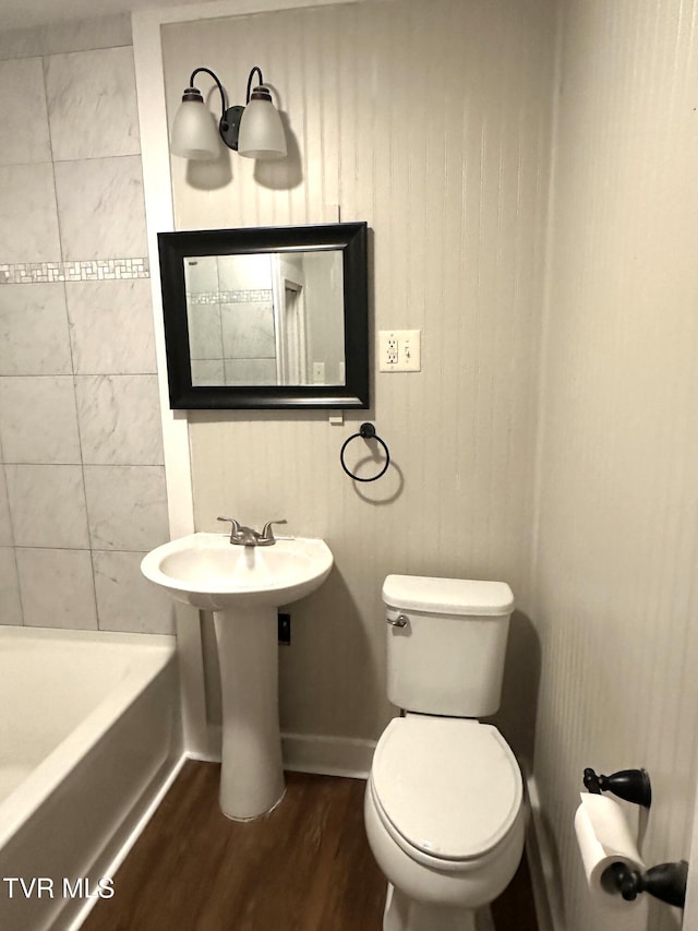 bathroom featuring toilet, wood finished floors, and baseboards