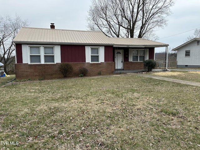 ranch-style home with brick siding, board and batten siding, a front yard, a chimney, and metal roof