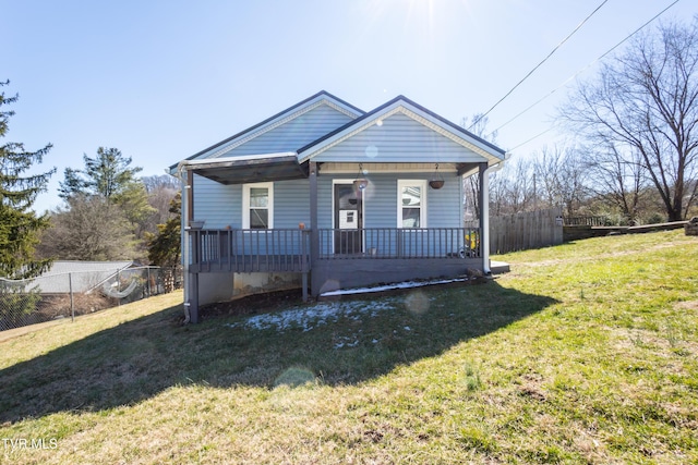 bungalow featuring a porch, a front lawn, and fence