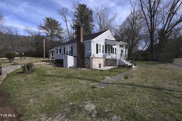 view of side of home featuring a lawn and covered porch