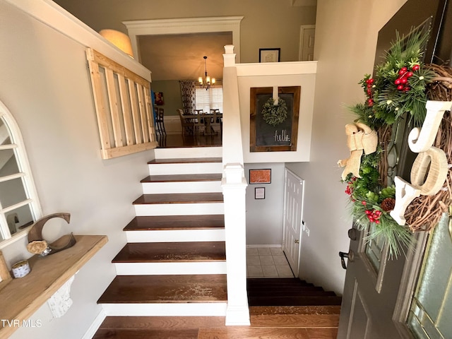 staircase with a notable chandelier