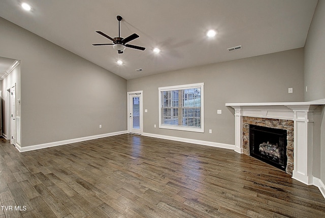 unfurnished living room with ceiling fan, dark hardwood / wood-style floors, vaulted ceiling, and a stone fireplace