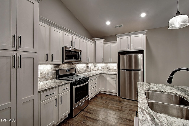 kitchen featuring sink, decorative light fixtures, stainless steel appliances, light stone countertops, and white cabinets