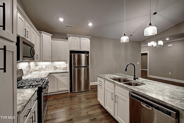 kitchen featuring light stone countertops, white cabinetry, appliances with stainless steel finishes, and sink