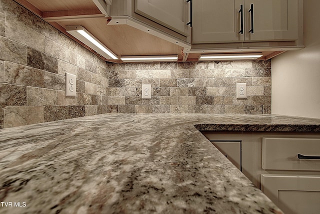 interior details featuring decorative backsplash and stone counters