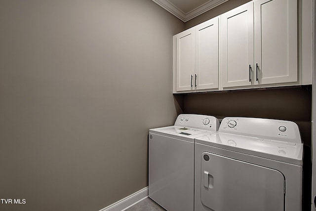 washroom featuring cabinets, crown molding, and washer and clothes dryer