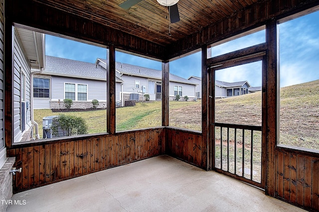 unfurnished sunroom featuring wood ceiling and ceiling fan