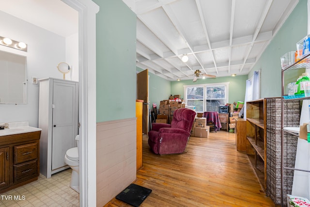 recreation room with coffered ceiling, sink, light wood-type flooring, ceiling fan, and beam ceiling