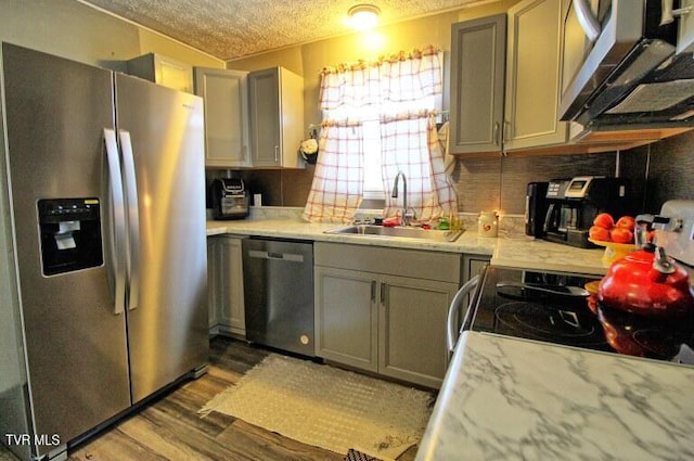 kitchen with appliances with stainless steel finishes, gray cabinets, and sink