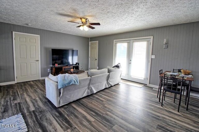 living room with dark hardwood / wood-style flooring, ceiling fan, french doors, and a textured ceiling