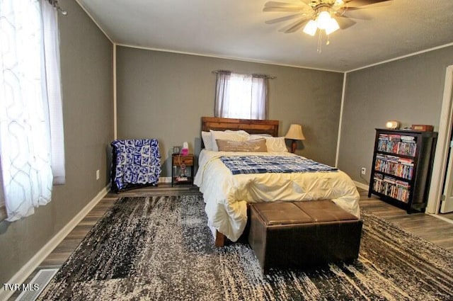 bedroom with ceiling fan, crown molding, and dark hardwood / wood-style flooring