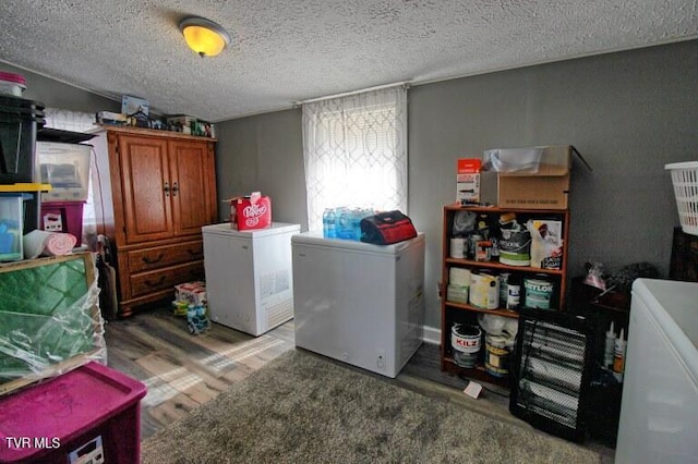 clothes washing area with dark hardwood / wood-style floors, washing machine and clothes dryer, and a textured ceiling