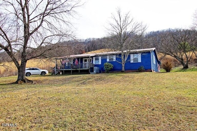 ranch-style house featuring a front yard and a deck