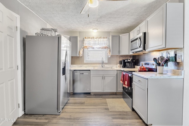 10955 Middle Wallens Creek Rd, Jonesville, VA 24263 - kitchen with appliances with stainless steel finishes, a textured ceiling, ceiling fan, light wood finished floors, and a sink