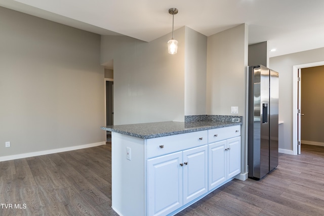 kitchen featuring dark wood-style flooring, white cabinets, stainless steel fridge, a peninsula, and baseboards