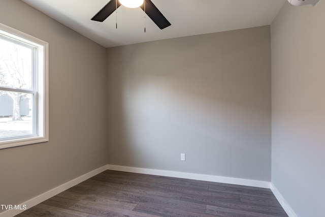 spare room with ceiling fan, dark wood finished floors, and baseboards