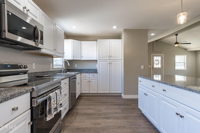 kitchen featuring stainless steel appliances, white cabinetry, a sink, and dark wood-type flooring