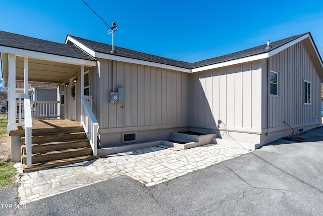 view of front of home with a patio and roof with shingles