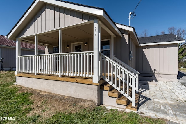 exterior space featuring a porch, a shingled roof, and board and batten siding