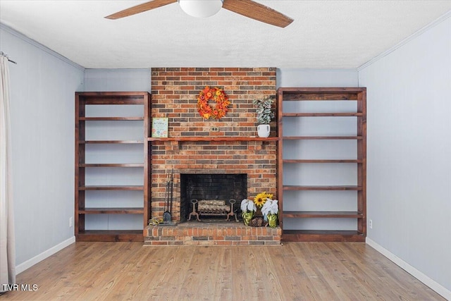 unfurnished living room featuring light wood-style floors, a fireplace, ornamental molding, and ceiling fan