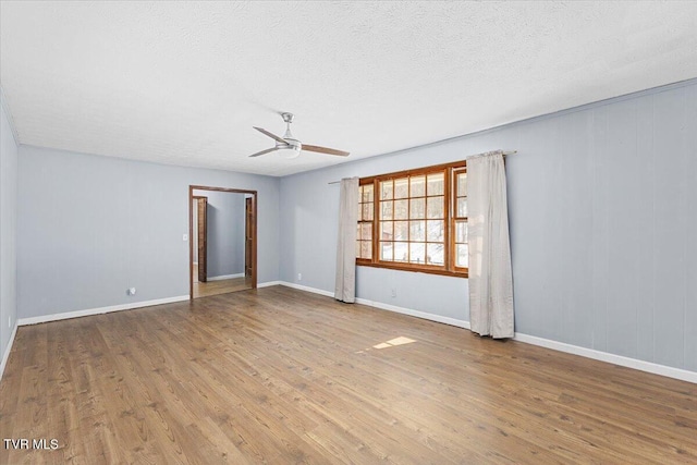 unfurnished room featuring ceiling fan, a textured ceiling, baseboards, and wood finished floors