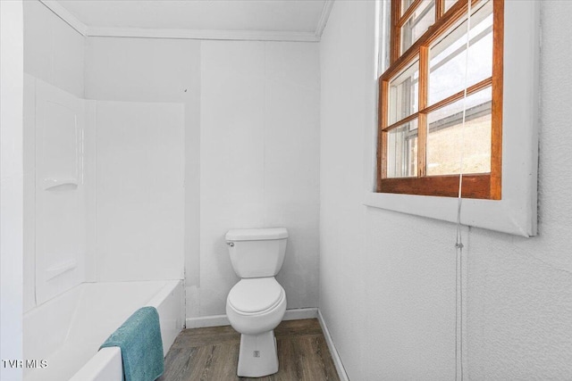 bathroom with baseboards, wood finished floors, toilet, and crown molding