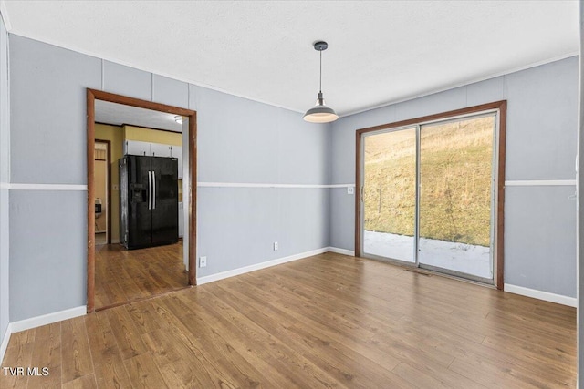 empty room with baseboards and wood finished floors