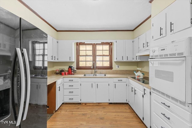 kitchen featuring black appliances, white cabinetry, light countertops, and a sink