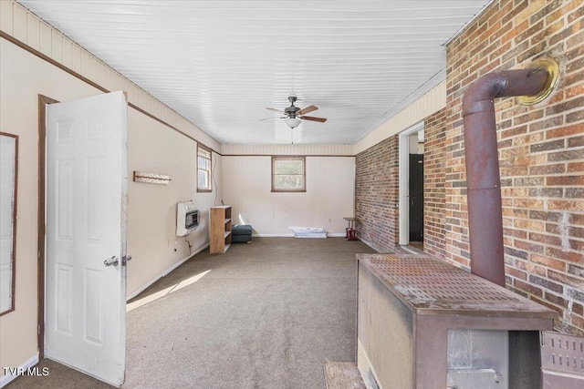 unfurnished sunroom featuring a ceiling fan and heating unit