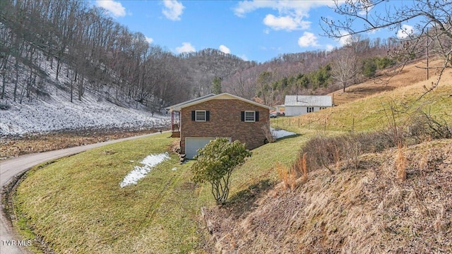 view of property exterior with an attached garage and brick siding