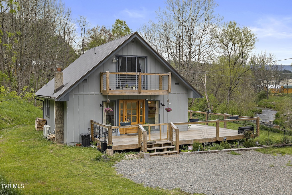 view of front of home with a balcony, a front yard, and a deck